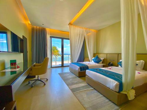 a bedroom with two beds and a desk and a window at Matemwe Sands Beach Resort in Mkuyuni Pwani