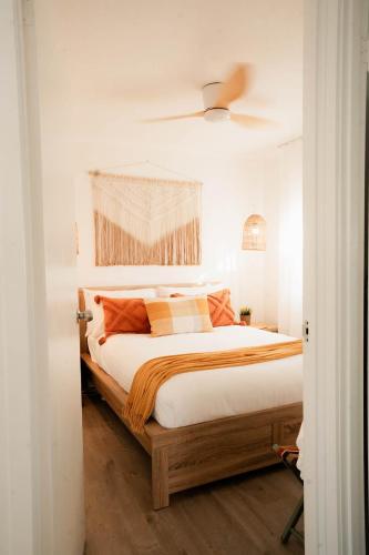 a bedroom with a large bed with orange pillows at Oceanview Beach Shack with Pool & Walk to Dining in Aldinga Beach