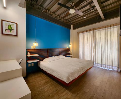 a bedroom with a bed and a blue wall at Torre Yaxche Urban Center in Cancún