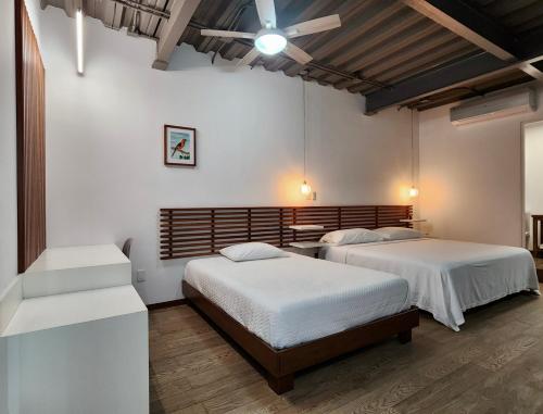 two beds in a room with white walls at Torre Yaxche Urban Center in Cancún
