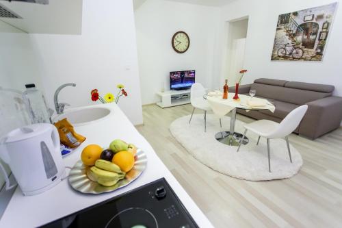 a kitchen and living room with a plate of fruit on a counter at Iassium Residence Iasi in Iaşi