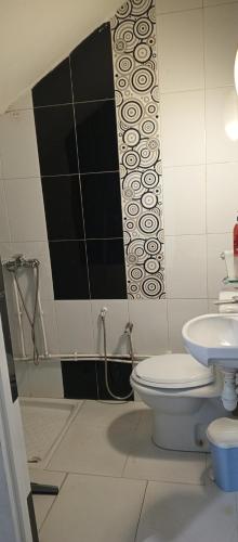 a bathroom with a toilet and a sink at Maison de vacance in Bin Rhilouf