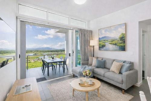 a living room with a couch and a table at Home To Holiday at Holborn Apartments in Townsville in Townsville
