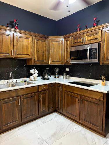 a kitchen with wooden cabinets and a microwave at Ancla Suites in Puerto Peñasco