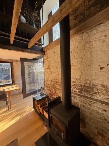 a fireplace in a room with a brick wall at The Barn Tasmania in Hobart