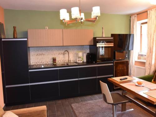 a kitchen with a sink and a table in a room at Hammonds Jura Ferienwohnungen in Kasendorf