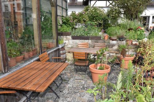 a patio with a wooden table and chairs and plants at Hammonds Jura Ferienwohnungen in Kasendorf