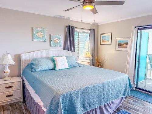 a bedroom with a bed with blue sheets and a window at Ocean Shores 301 in North Myrtle Beach
