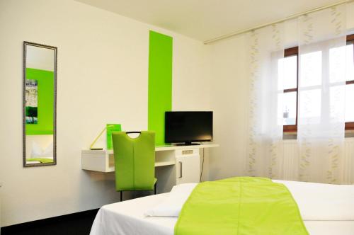 a hotel room with a bed and a television at Hotel zum Brunnen in Friedberg