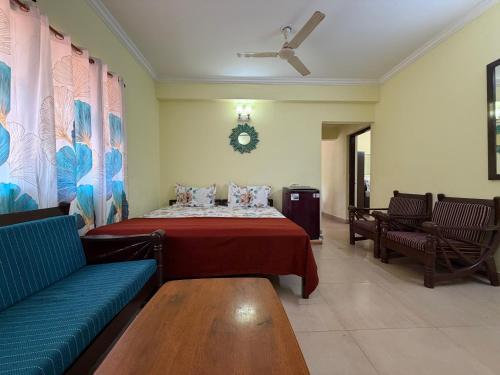 a bedroom with a bed and a couch in a room at Goa Homeland 3 double bed Calangute in Calangute