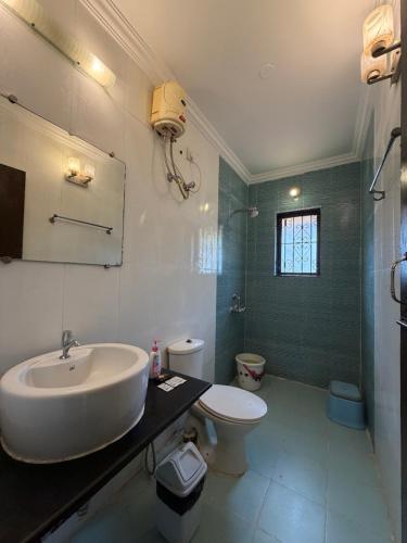 a bathroom with a sink and a toilet at Goa Homeland 3 double bed Calangute in Calangute