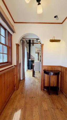 an empty room with a wooden floor and a table at KOGUMA AKIRUNO villa in Akiruno