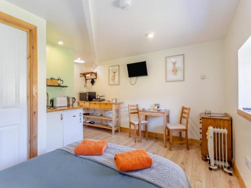 a bedroom with a bed and a kitchen with a table at Beinn Uidhe Studio Apartment - Uk49100 in Inchnadamph