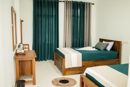 a bedroom with two beds and a window with green curtains at Rainforest Jungle Chill Singharaja in Deniyaya