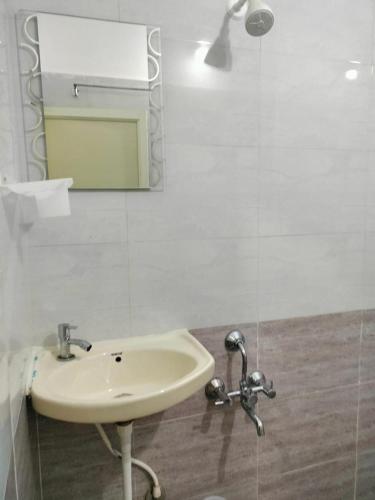 a bathroom with a sink and a mirror at ISIRI Rooms in Mysore