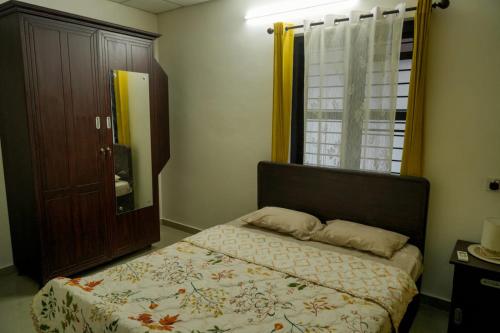 a small bedroom with a bed and a window at Neerbhoomi in Kollam