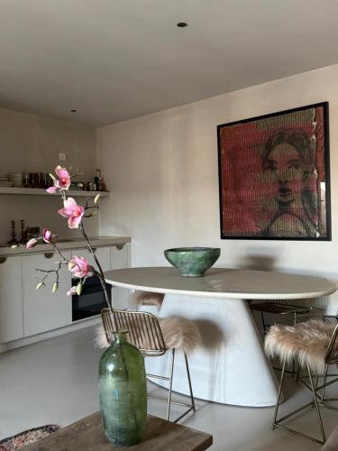 a dining room with a table and a vase with flowers at appartementen zeespiegel in Zandvoort