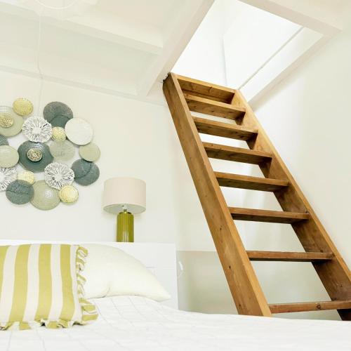 a staircase in a bedroom with a bed and a lamp at Chalet Le Reposou in Laguiole