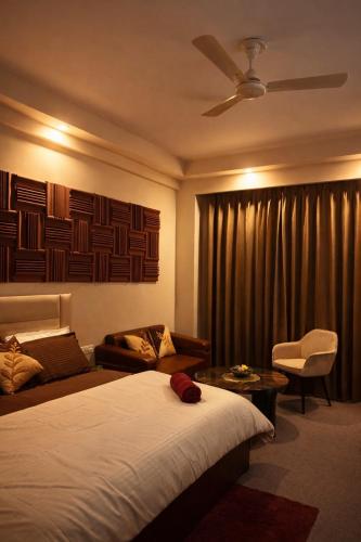 a hotel room with a bed and a couch and a window at Midnight Atelier in Greater Noida