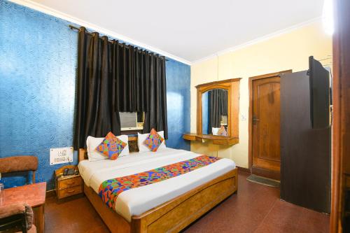 a bedroom with a bed and a tv in it at FabHotel Vardhmaan Inn in New Delhi