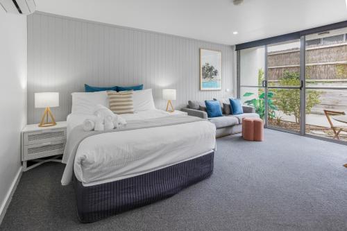 a bedroom with a large bed and a couch at Bay View Style in Lorne