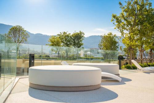 two white tables and chairs in front of a window at Laguna Beachside residences apartamens, walking distance to the sea in Bang Tao Beach