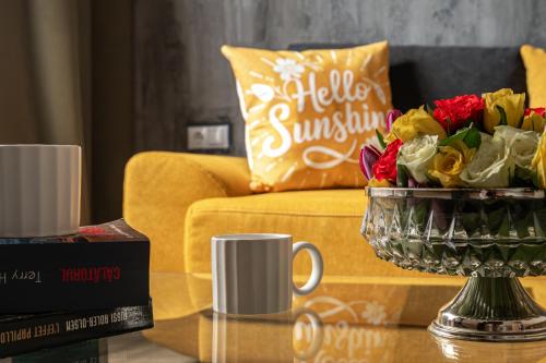 a coffee table with a vase of flowers on a couch at ARI Central Location in Arad