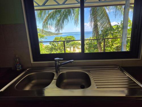 un lavello da cucina con una finestra con vista sull'oceano di Te Fare Ninamu a Taputapuapea