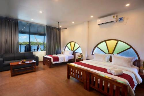 a hotel room with a large bed and a couch at Akanta Cherai Beach Resort in Cochin