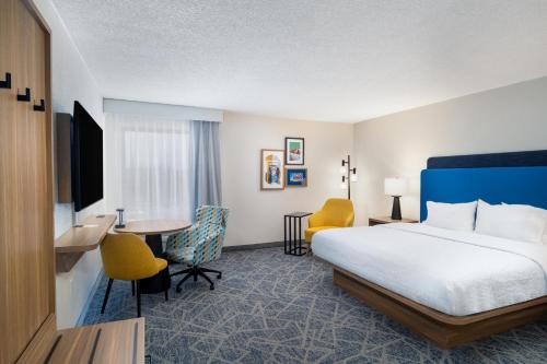 a hotel room with a bed and a table and chairs at Hampton Inn Marietta in Marietta
