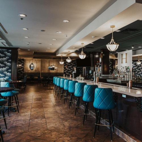 a bar with blue chairs in a restaurant at Hilton Dallas Southlake Town Square in Southlake