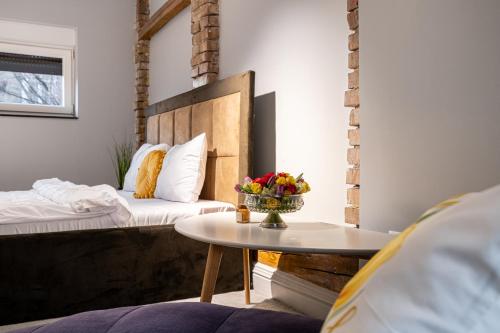 a room with two beds and a table with flowers at ARI Central Location in Arad