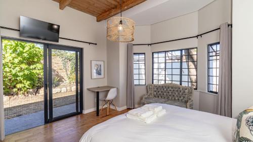 a bedroom with a bed and a tv and windows at The Wellington Residence in George
