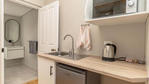 a small kitchen with a sink and a microwave at The Wellington Residence in George