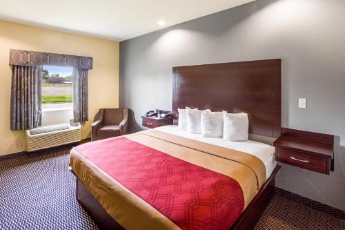 a hotel room with a large bed and a window at Econo Lodge Baton Rouge University Area in Baton Rouge