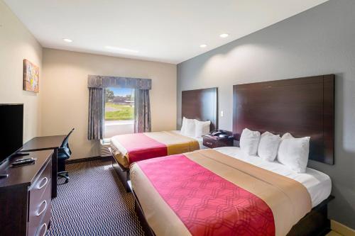 a hotel room with two beds and a television at Econo Lodge Baton Rouge University Area in Baton Rouge