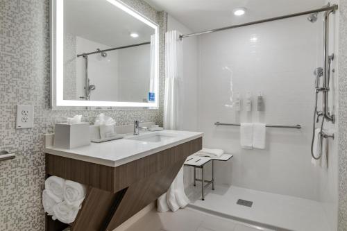 a white bathroom with a sink and a shower at Home2 Suites by Hilton Bangor in Bangor