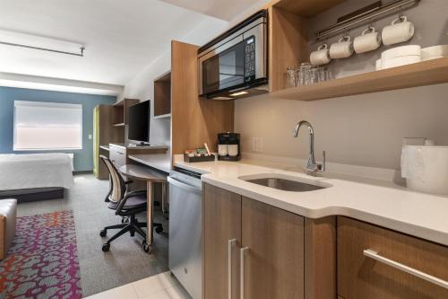 a kitchen with a sink and a desk in a room at Home2 Suites by Hilton Bangor in Bangor