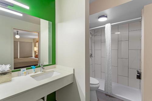 a bathroom with a sink and a toilet and a mirror at Heights House Hotel - Houston Heights Downtown, an Ascend Collection Hotel in Houston