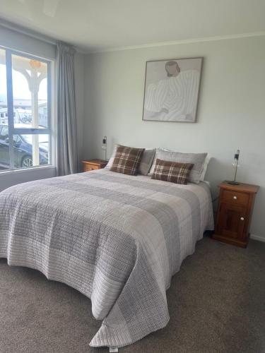 a bedroom with a large bed and a window at Cosy & close to town in Te Anau