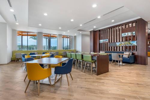 a dining room with tables and chairs and windows at Comfort Inn & Suites Orlando Sanford Airport in Sanford