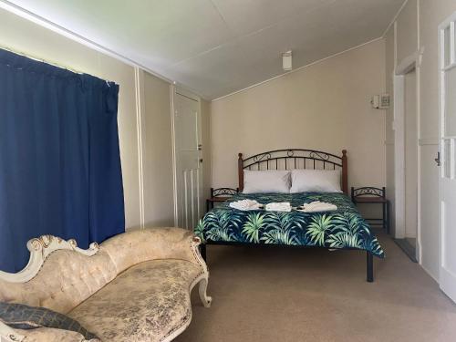 a bedroom with a bed and a blue curtain at Wild Platypus Stays in Eungella