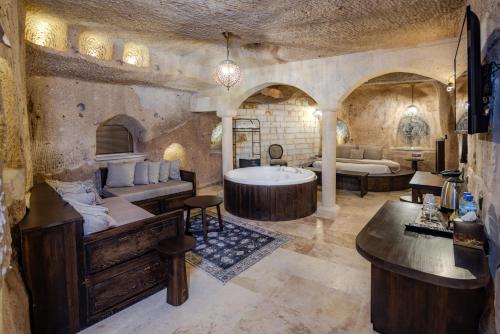 a bathroom with a tub and a bed and a bath room at Castellum Cave Cappadocia in Uçhisar