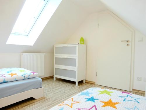 a bedroom with a bed and a white cabinet at Ferienwohnung Seenlandwinkel in Wackersdorf