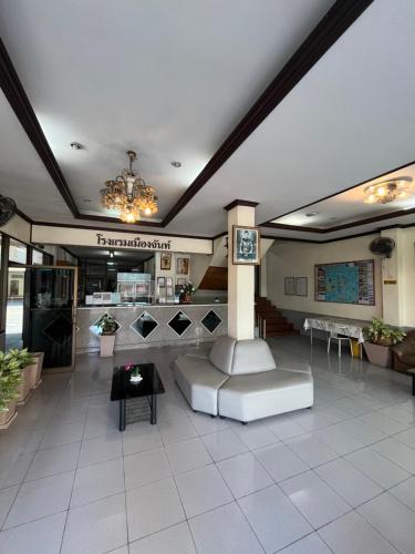 a lobby with a clock on a column in a building at Muangchan Hotel in Chanthaburi
