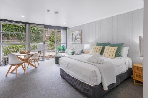 a bedroom with a large bed and a table and chairs at Bay View - Palm Springs in Lorne