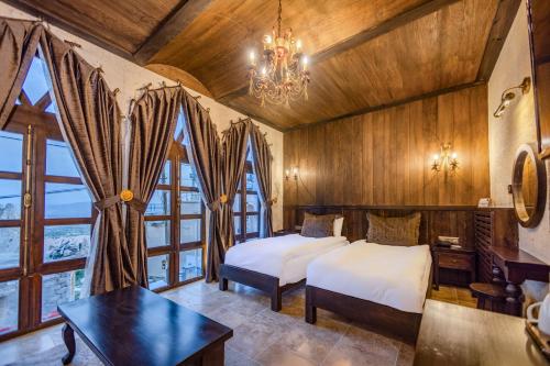 a bedroom with two beds and a chandelier at Castellum Cave Cappadocia in Uçhisar
