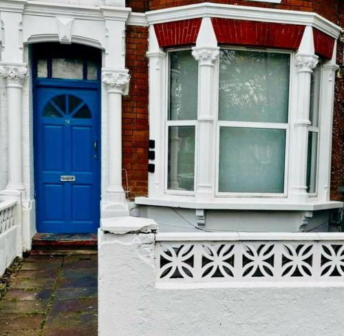 a blue door on the side of a building at Tottenham City Stays, Opposite Seven Sisters Train Station in London