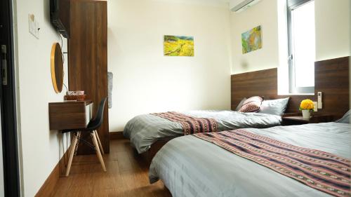 a hotel room with two beds and a window at XƠ ĐĂNG homestay in Kon Plong