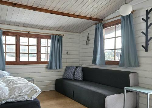 a living room with a couch and blue curtains at Bygholm Camping og aktiviteter in Vesløs